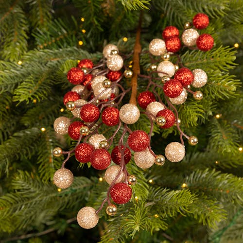 Branche décorative de Noël avec boules rouges, irisées et or