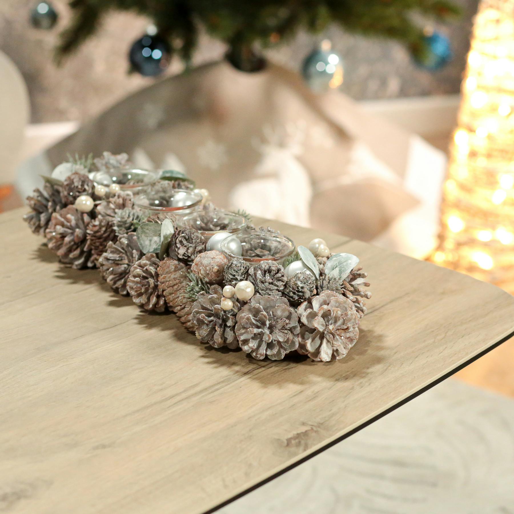Centre de table de Noël effet givré avec pommes de pin, baies et 4 bougeoirs en verre