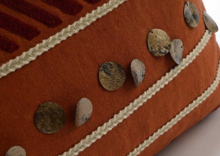 Coussin Pocahontas touché doux couleur brique avec motifs en relief inspiration Aztek, boutons et pompons 40x40cm
