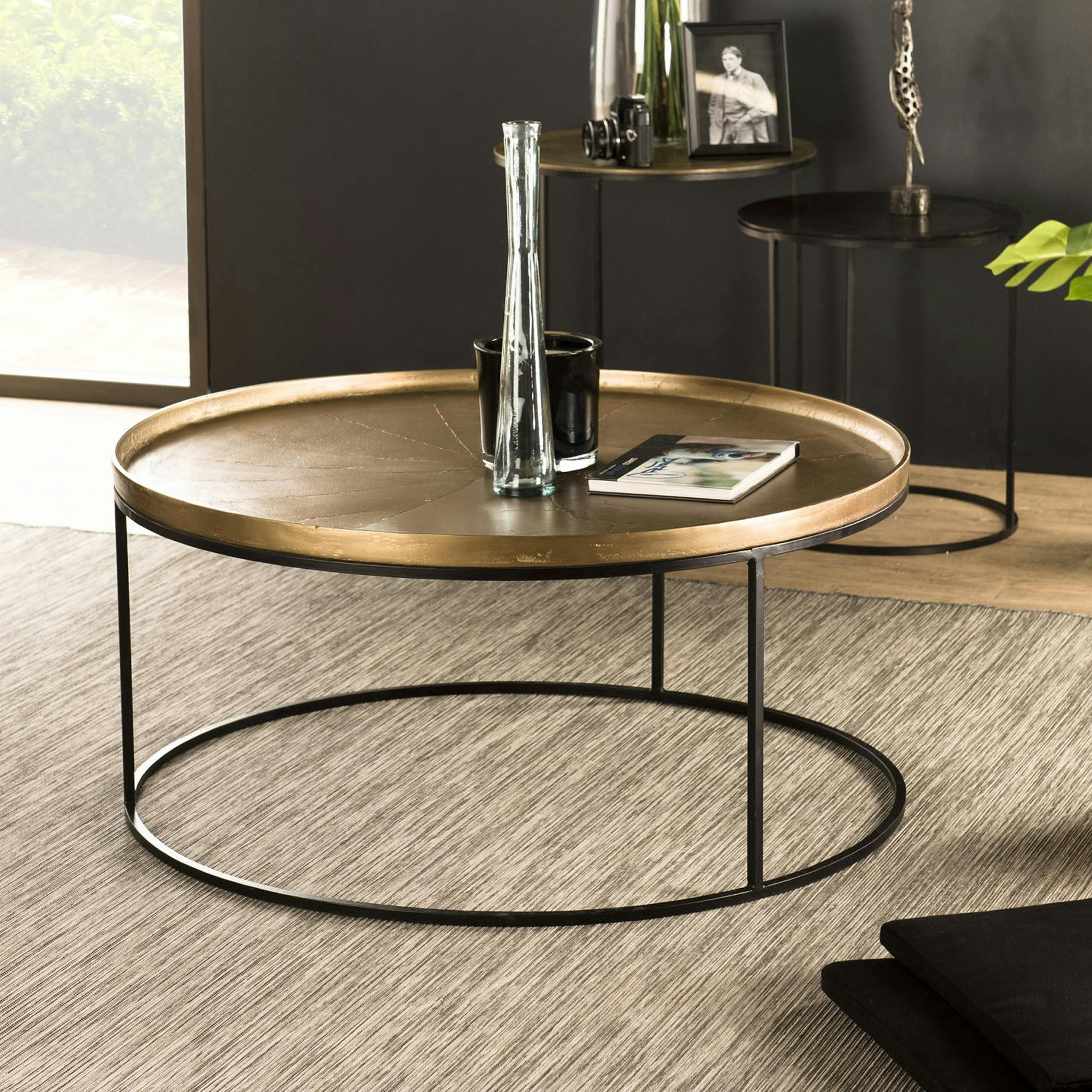 Table basse ronde en metal dore et noir de style contemporain