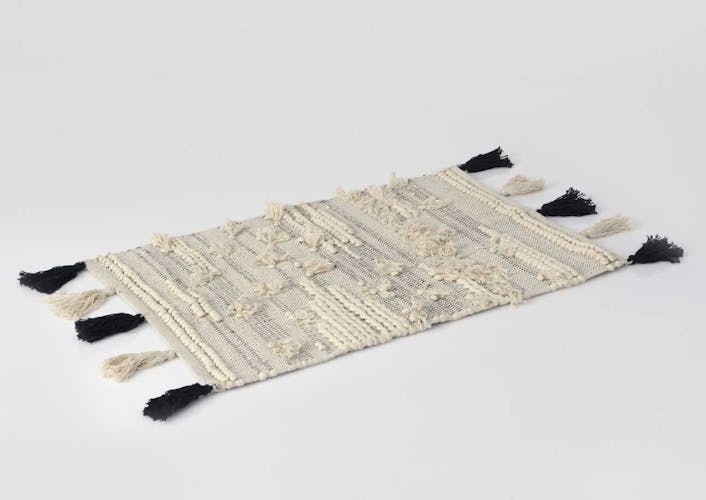 Tapis Evasion tissage coton couleur naturelle avec pompons noirs et écrus 80x120cm